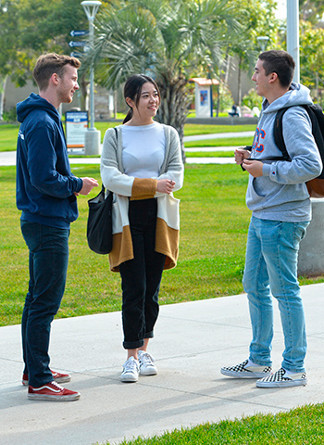 3 students talking in the library quad
