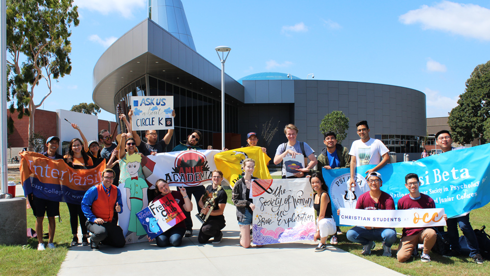 Students holding student club banners in front of the planetarium